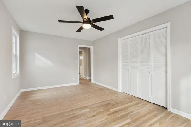 a view of a livingroom with a ceiling fan & wooden floor