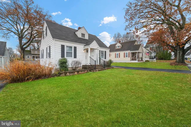 a front view of a house with a garden and trees