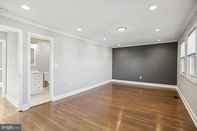 a view of an empty room with wooden floor