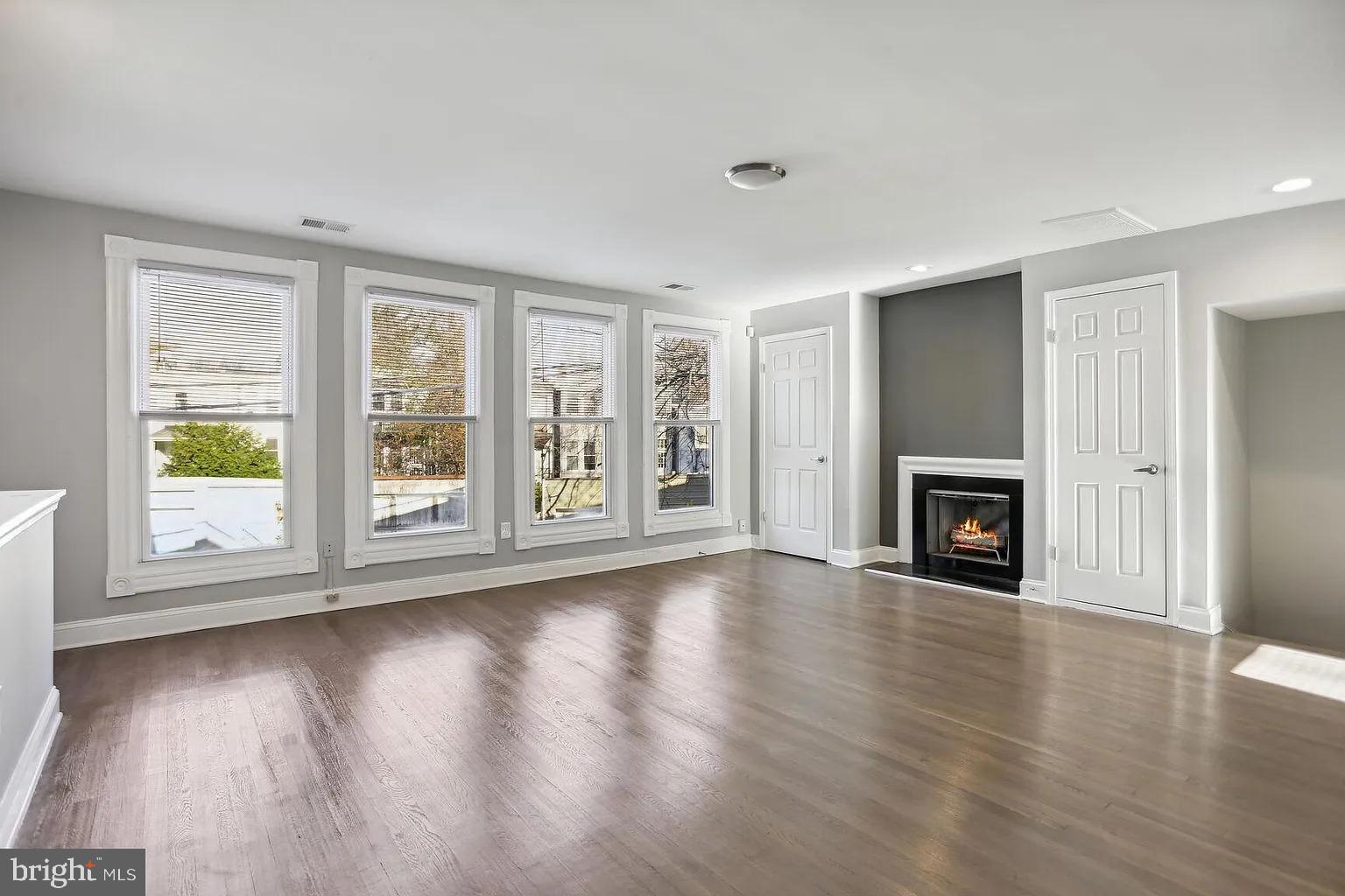 1507 Freedom Way Southeast, Unit 2 Washington, DC 20003 - Photo 5 of 22 an empty room with wooden floor fireplace and windows