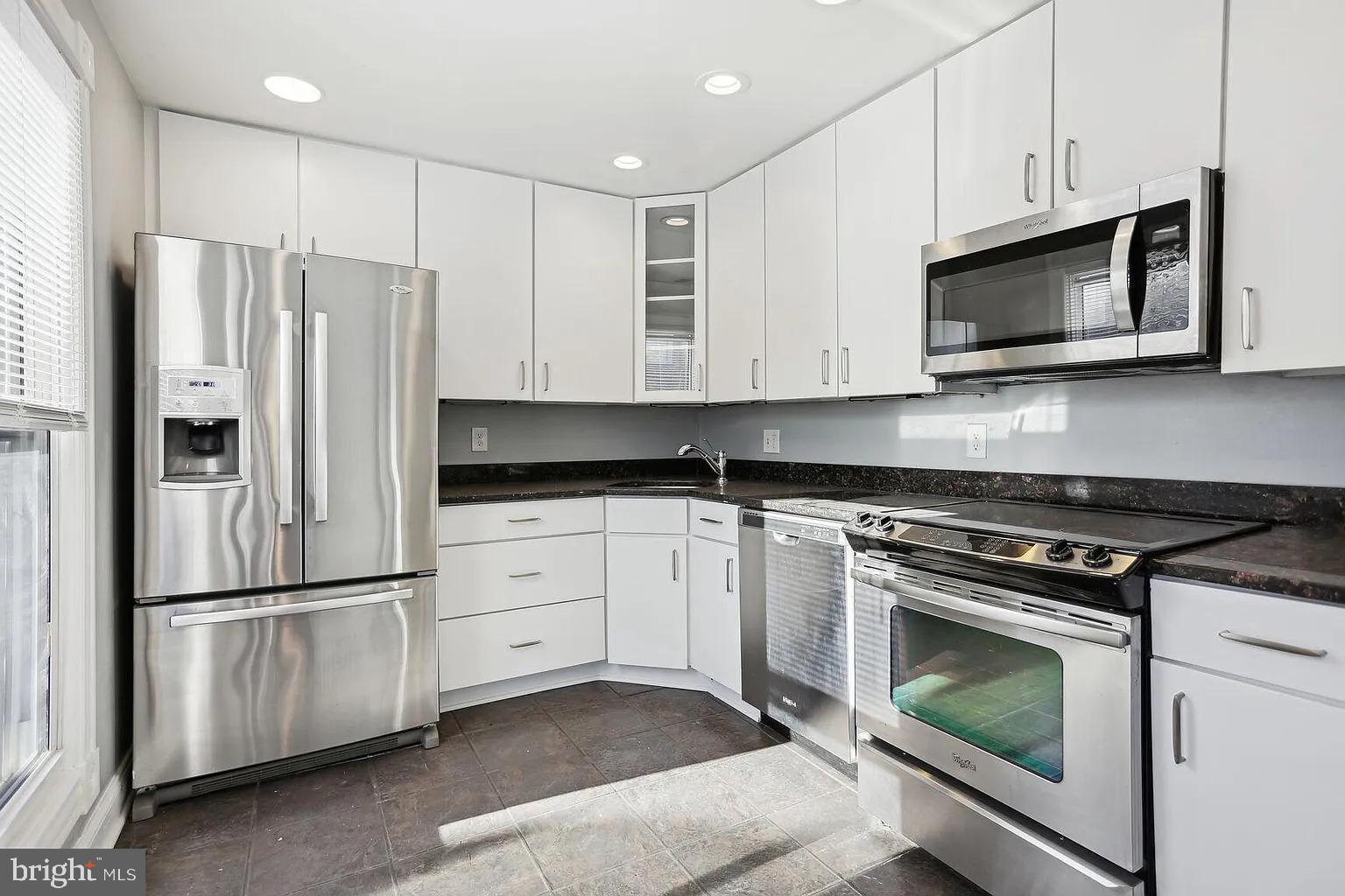 1507 Freedom Way Southeast, Unit 2 Washington, DC 20003 - Photo 8 of 22 a kitchen with stainless steel appliances white cabinets white stove a microwave and a refrigerator