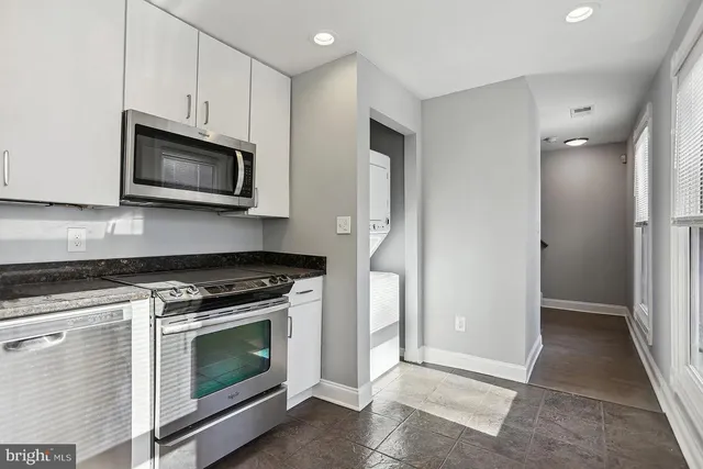a kitchen with stainless steel appliances a stove microwave and sink