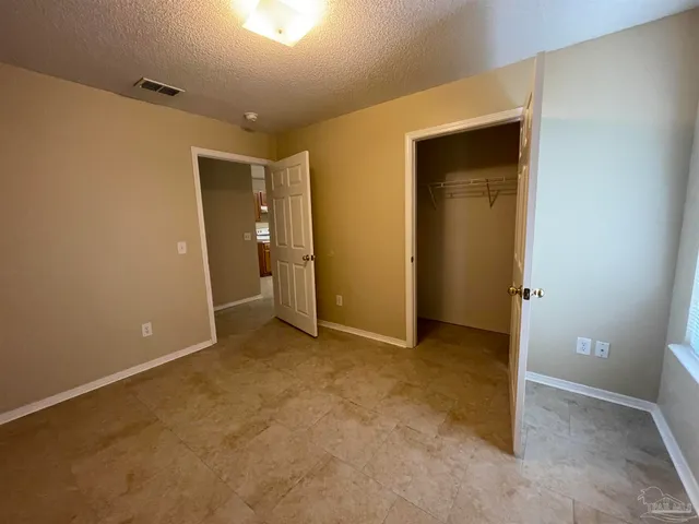 an empty room with closet and a bathroom