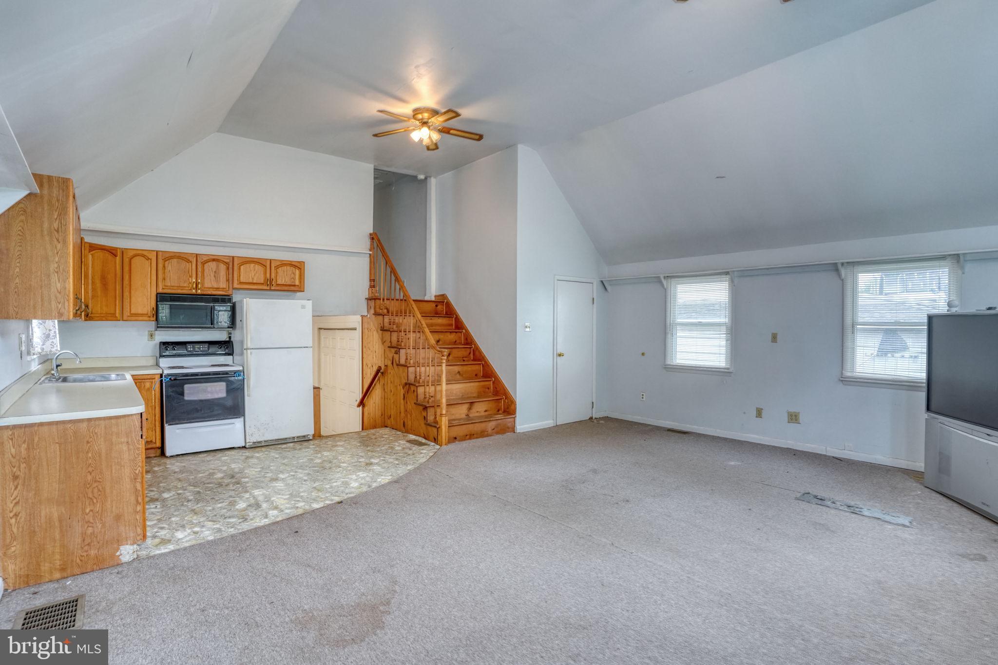 257 Front Street Leipsic, DE 19901 - Photo 11 of 37 an empty room with chandelier fan and kitchen view