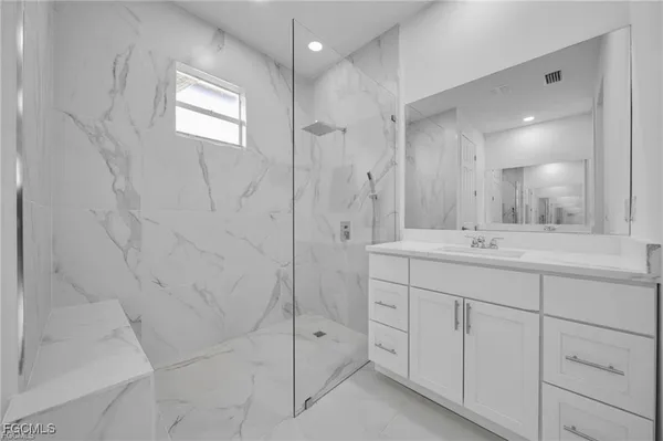 a bathroom with a shower sink and mirror