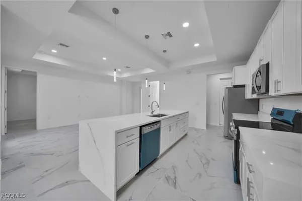 a kitchen with stainless steel appliances a sink a stove a refrigerator and cabinets