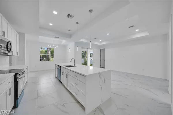 a large white kitchen with a large window