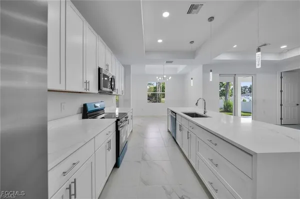 a large kitchen with stainless steel appliances lots of counter space sink and cabinets