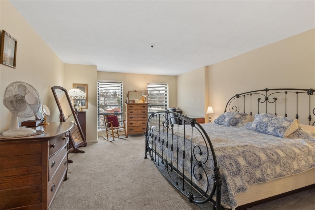 22 Railroad Street, Unit 504 Andover, MA 01810 - Photo 15 of 28 a bedroom with a bed next to a large window