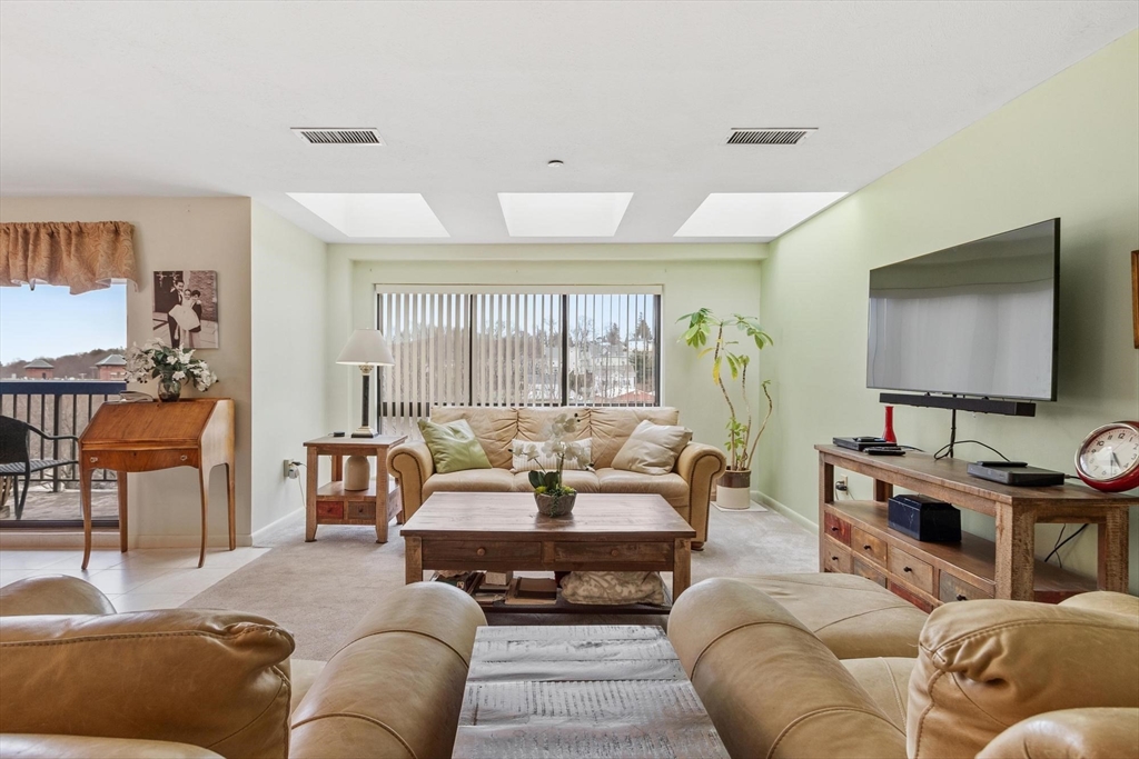 22 Railroad Street, Unit 504 Andover, MA 01810 - Photo 3 of 28 a living room with furniture and a flat screen tv