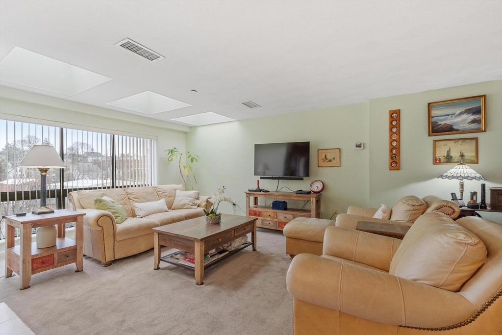 22 Railroad Street, Unit 504 Andover, MA 01810 - Photo 5 of 28 a living room with furniture and a flat screen tv