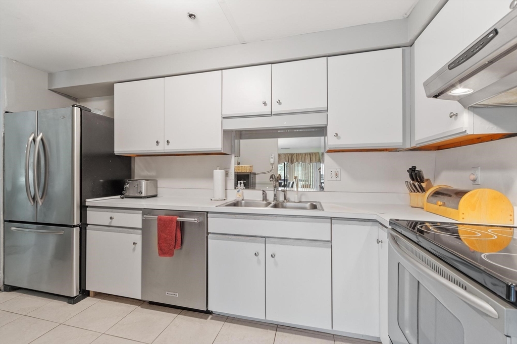 22 Railroad Street, Unit 504 Andover, MA 01810 - Photo 9 of 28 a kitchen with stainless steel appliances granite countertop a sink and cabinets