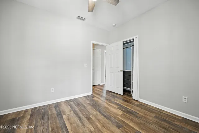 an aerial view of a residential houses with outdoor space and trees all around