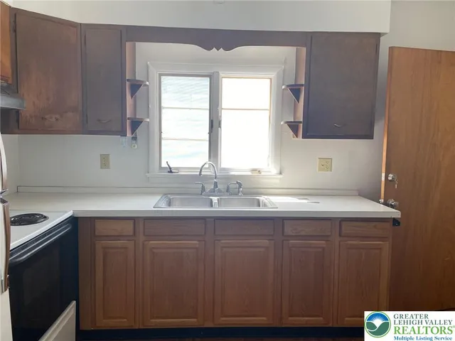 a kitchen with a sink cabinets and window