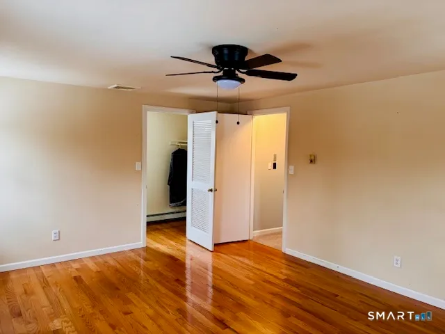 a view of empty room with wooden floor