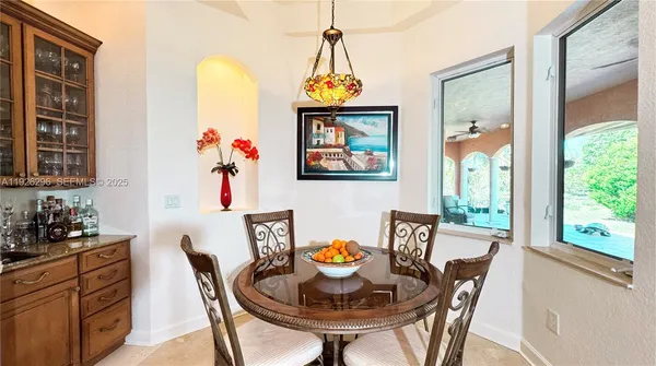 a vase of flowers besides of a sink