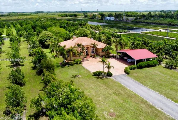 an aerial view of a house with yard tennis court