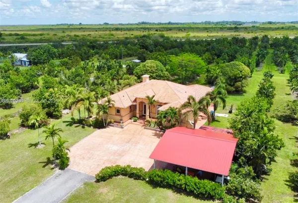 an aerial view of a house with yard and lake view