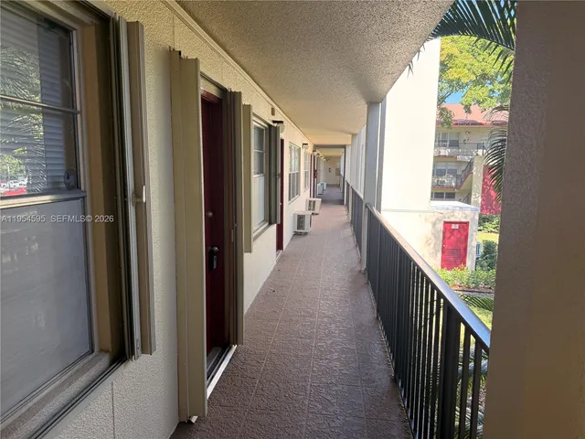 a hallway with wooden floor and stairs