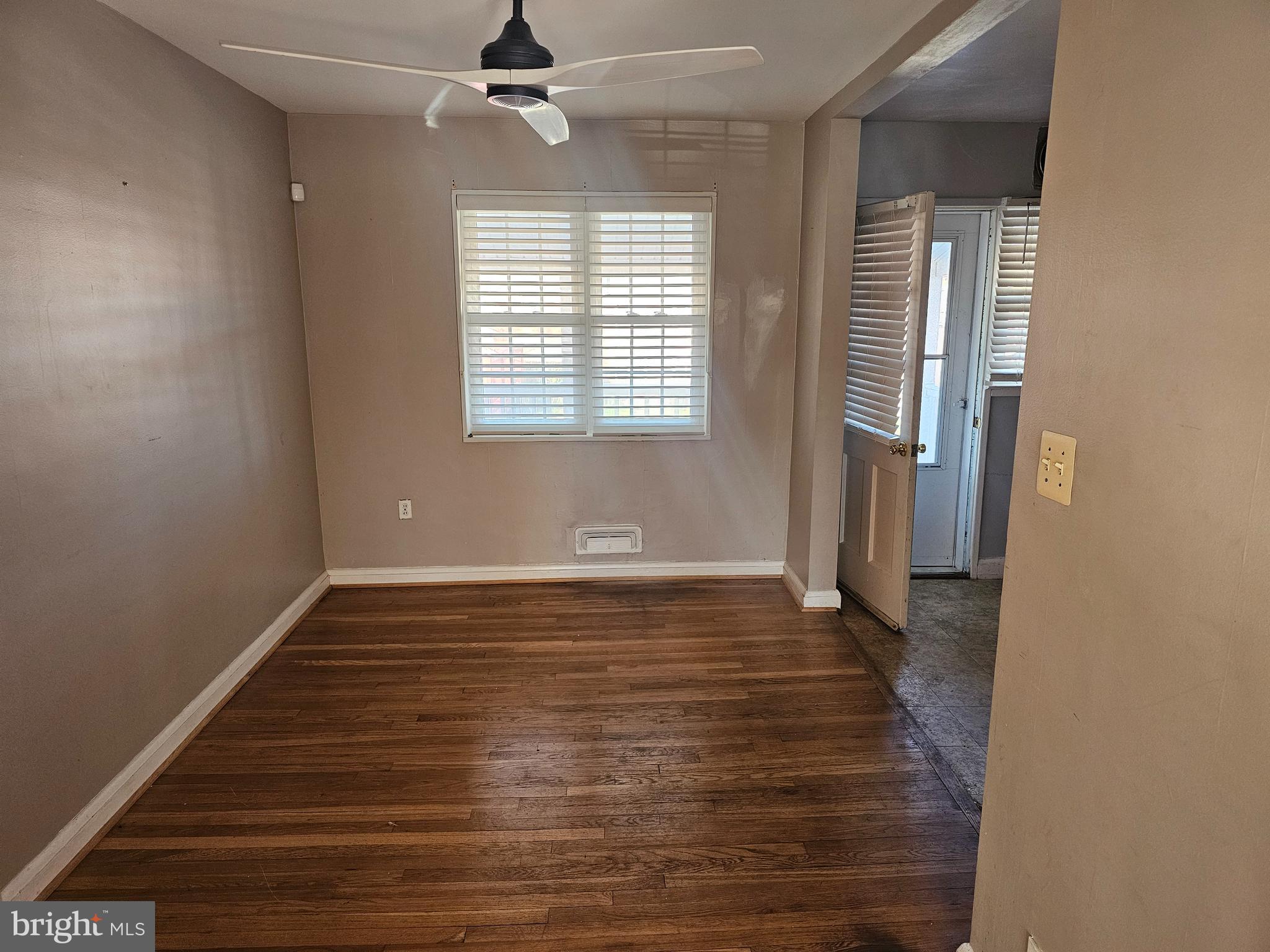 4728 Williston Street Baltimore, MD 21229 - Photo 4 of 17 a view of an empty room with wooden floor and a window