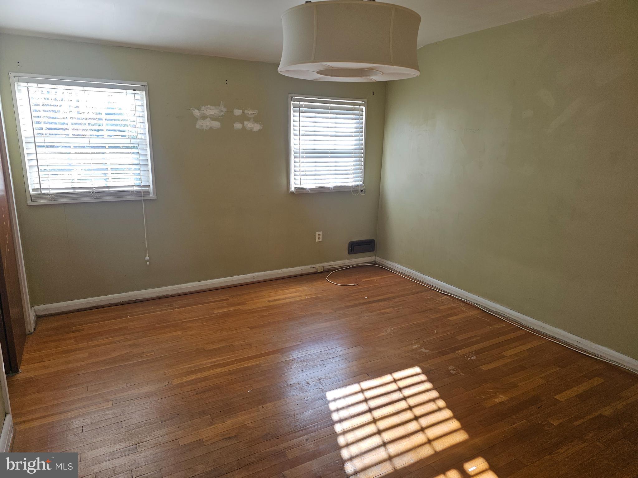 4728 Williston Street Baltimore, MD 21229 - Photo 7 of 17 an empty room with wooden floor and windows