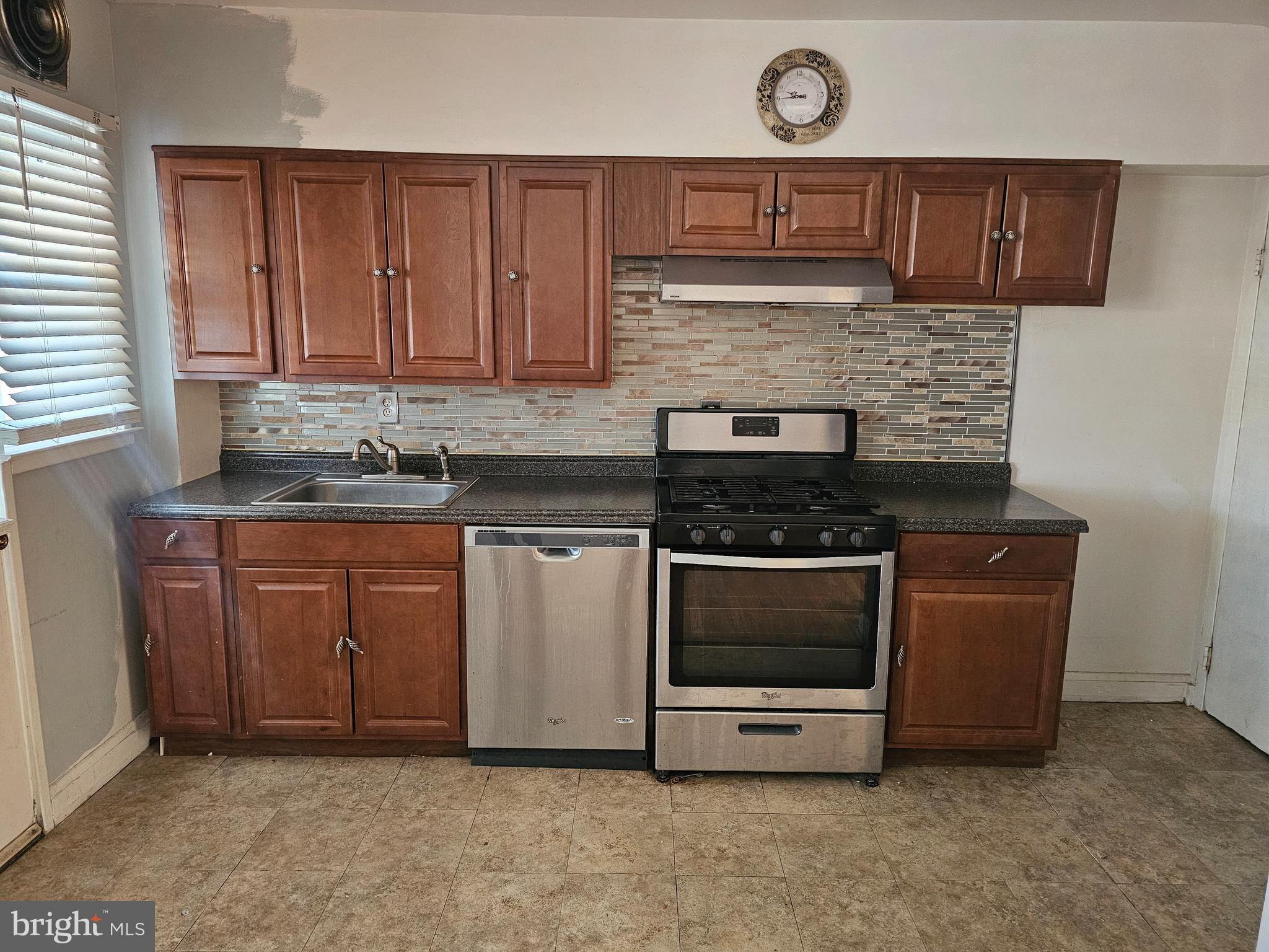 4728 Williston Street Baltimore, MD 21229 - Photo 10 of 17 a kitchen with granite countertop a stove a sink and a microwave