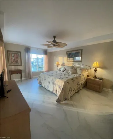 a spacious bedroom with a large bed and a chandelier