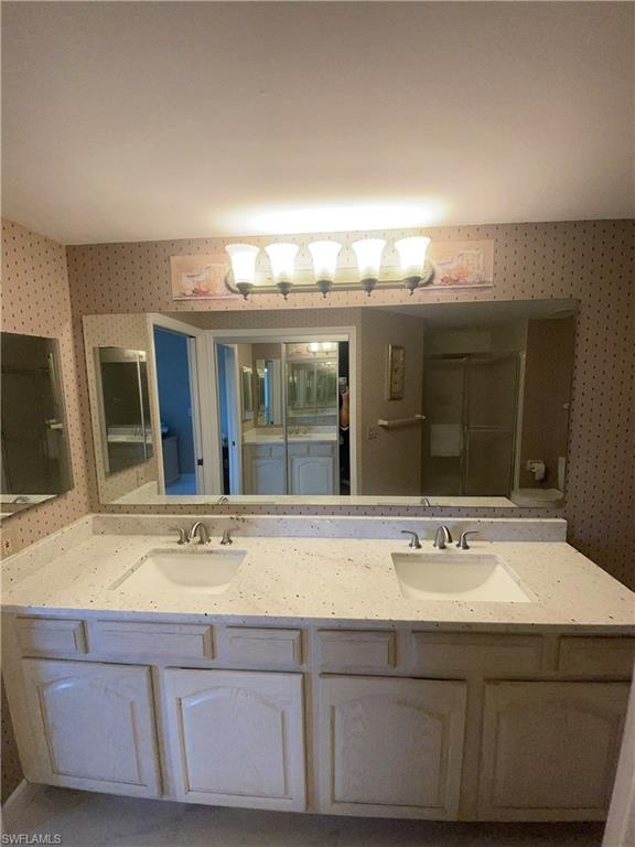 13105 Vanderbilt Drive, Unit 808 Naples, FL 34110 - Photo 18 of 26 a bathroom with a sink and a mirror