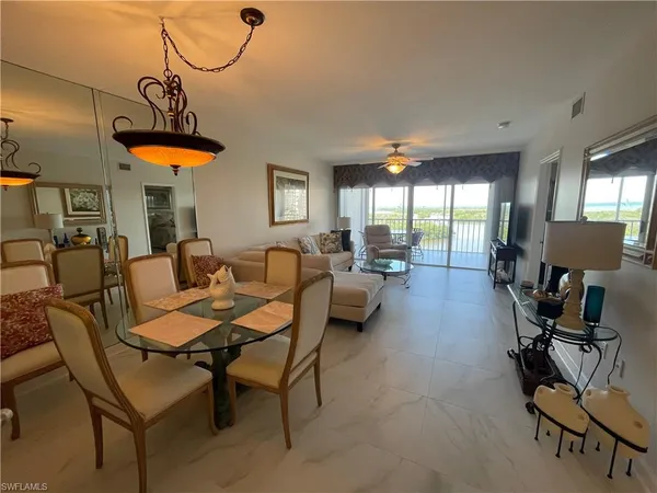 a living room with furniture a chandelier and a window