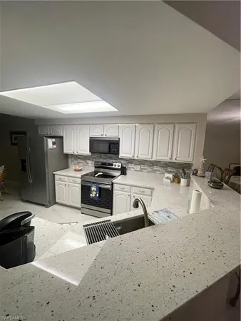 a kitchen with stainless steel appliances granite countertop a sink stove and cabinets