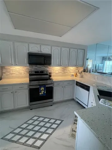 a kitchen with stainless steel appliances kitchen island granite countertop a stove a sink and a microwave