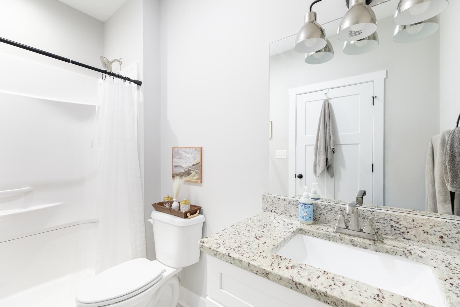 1301 Stoney Ridge Boulevard, Unit 208 Forest, VA 24551 - Photo 27 of 46 a bathroom with a granite countertop sink a toilet and a mirror