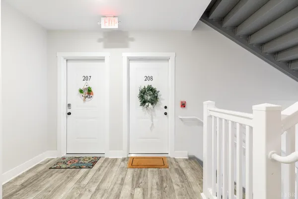 a view of a hallway with wooden floor and entryway