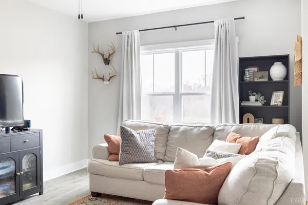 a living room with furniture a refrigerator and a window
