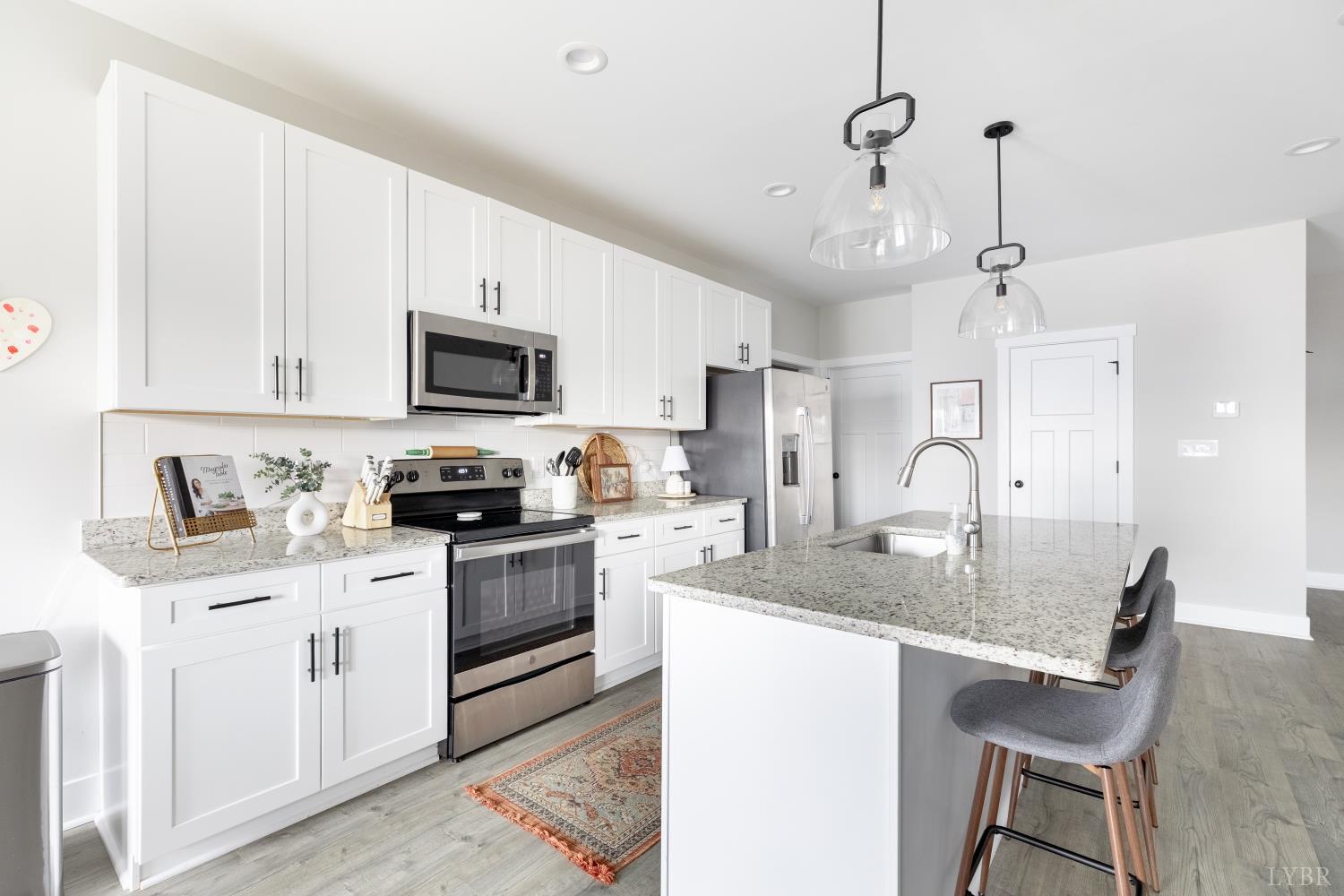1301 Stoney Ridge Boulevard, Unit 208 Forest, VA 24551 - Photo 7 of 46 a kitchen with a stove a sink a microwave a refrigerator a counter space and cabinets