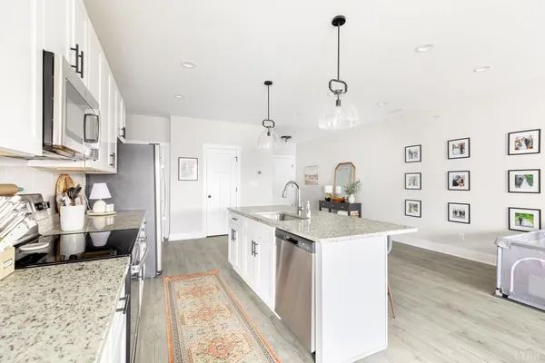 a kitchen with stainless steel appliances kitchen island granite countertop a sink stove and refrigerator