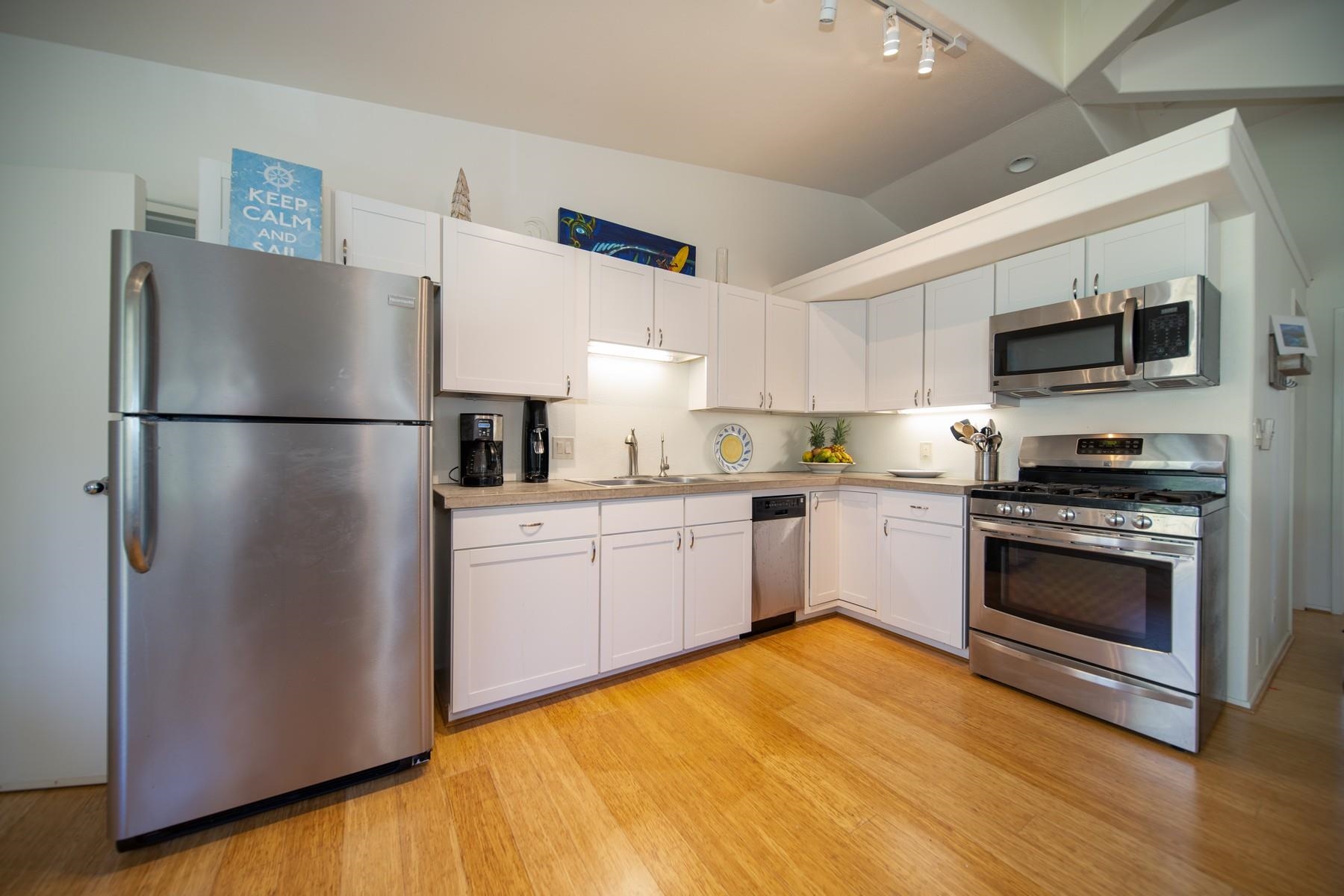 590 Stable Road, Unit C & D Paia, HI 96779 - Photo 11 of 30 a kitchen with a refrigerator a stove top oven a sink and cabinets