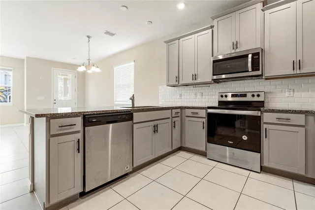 a kitchen with stainless steel appliances granite countertop a sink and a stove