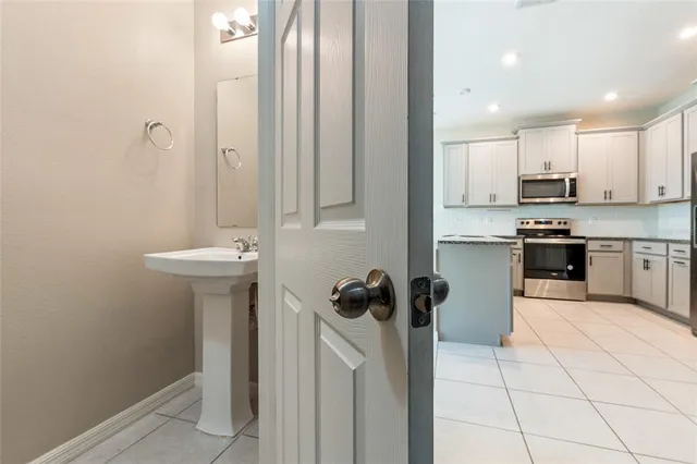 a kitchen with white cabinets and sink