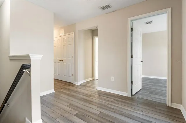a view of a hallway with wooden floor and staircase