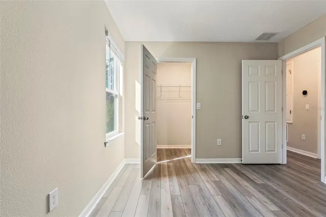 an empty room with wooden floor and a window