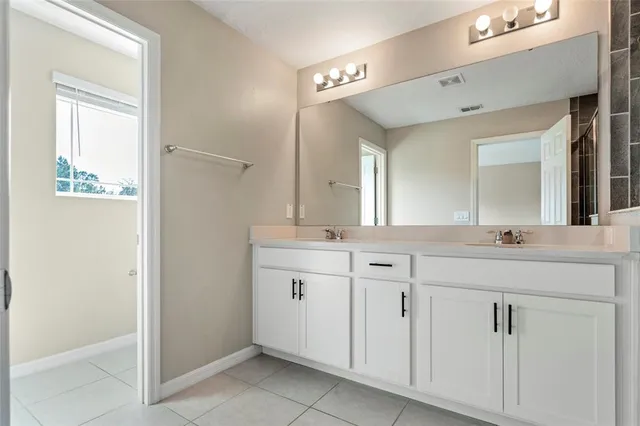 a spacious bathroom with a granite countertop sink a mirror and a