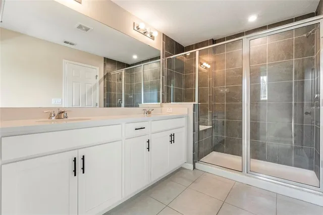 a bathroom with a shower sink and mirror