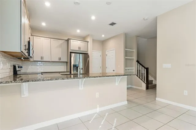 a kitchen with stainless steel appliances granite countertop a refrigerator and a sink