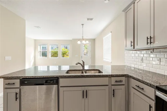 a kitchen with granite countertop a sink white cabinets and a granite counter tops