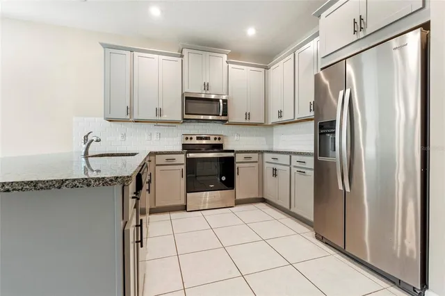 a kitchen with stainless steel appliances a refrigerator sink and cabinets