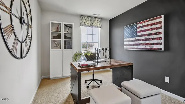 a view of a workspace with furniture and a window