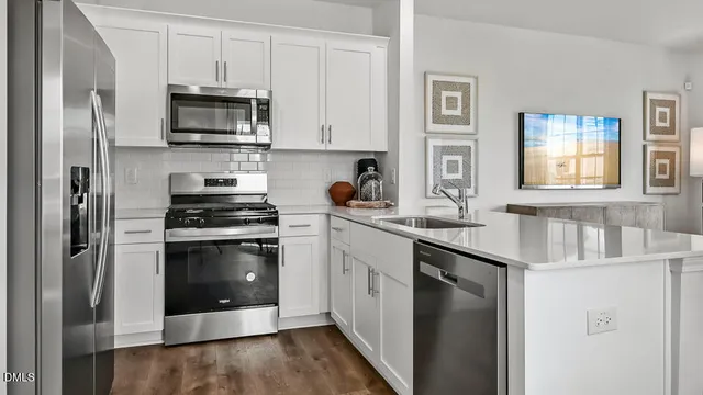 a kitchen with stainless steel appliances a stove a sink and a refrigerator