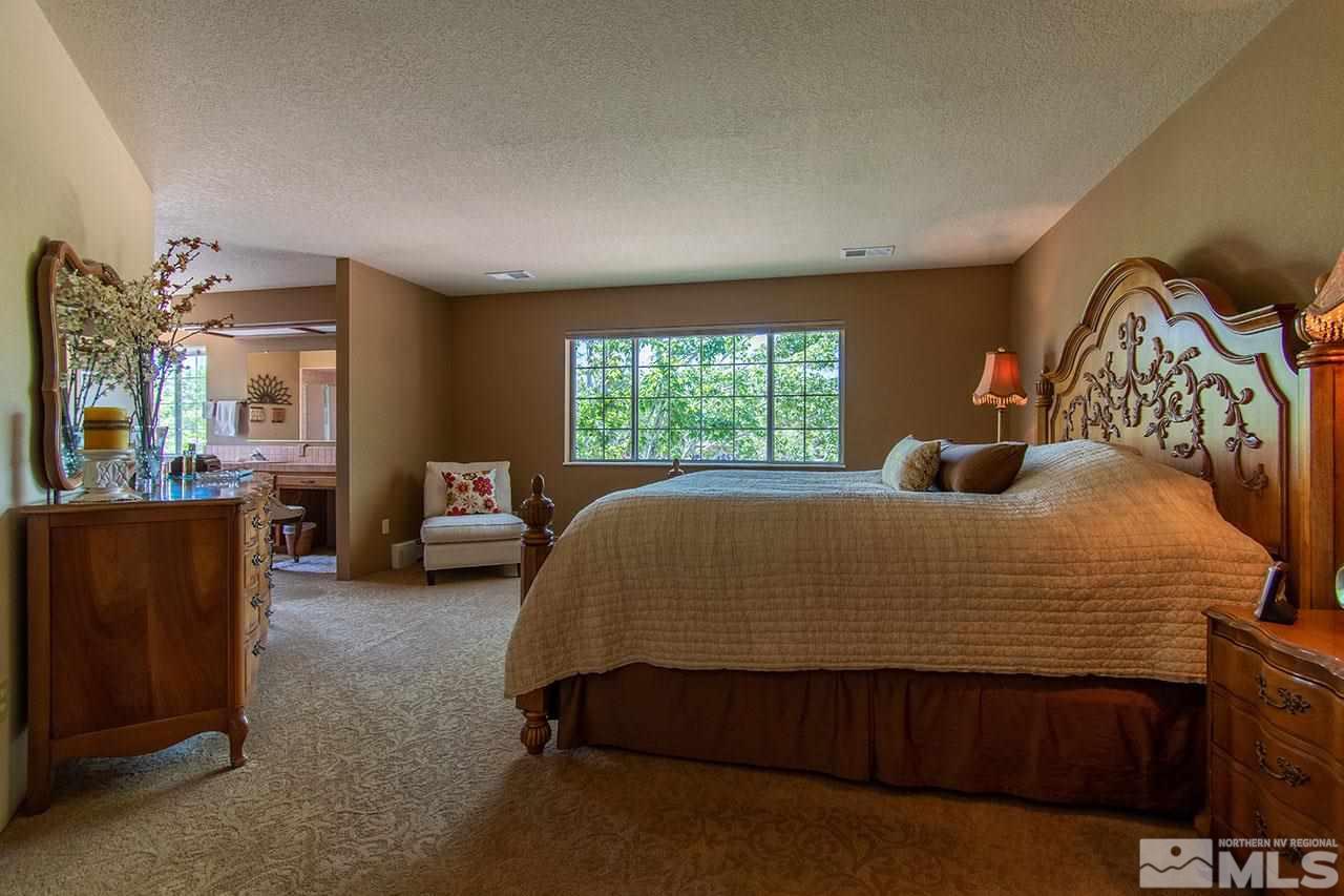 1155 Yates Lane Reno, NV 89509 - Photo 11 of 25 a bedroom with a bed and a dresser next to a window
