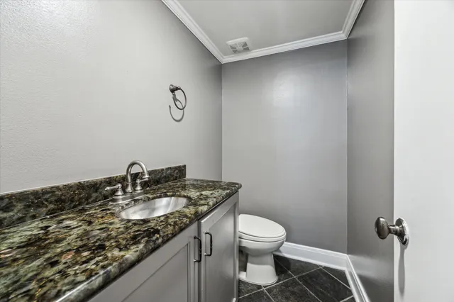 a bathroom with a granite countertop sink a toilet and a mirror